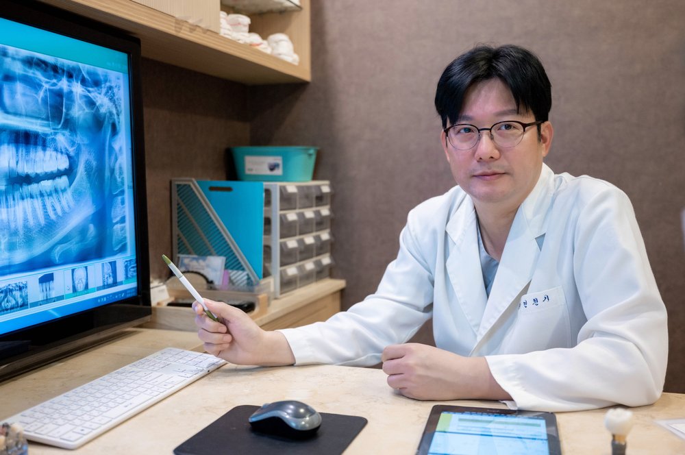 방사선 사진으로 치조골 상태를 설명하는 민천기 대표원장